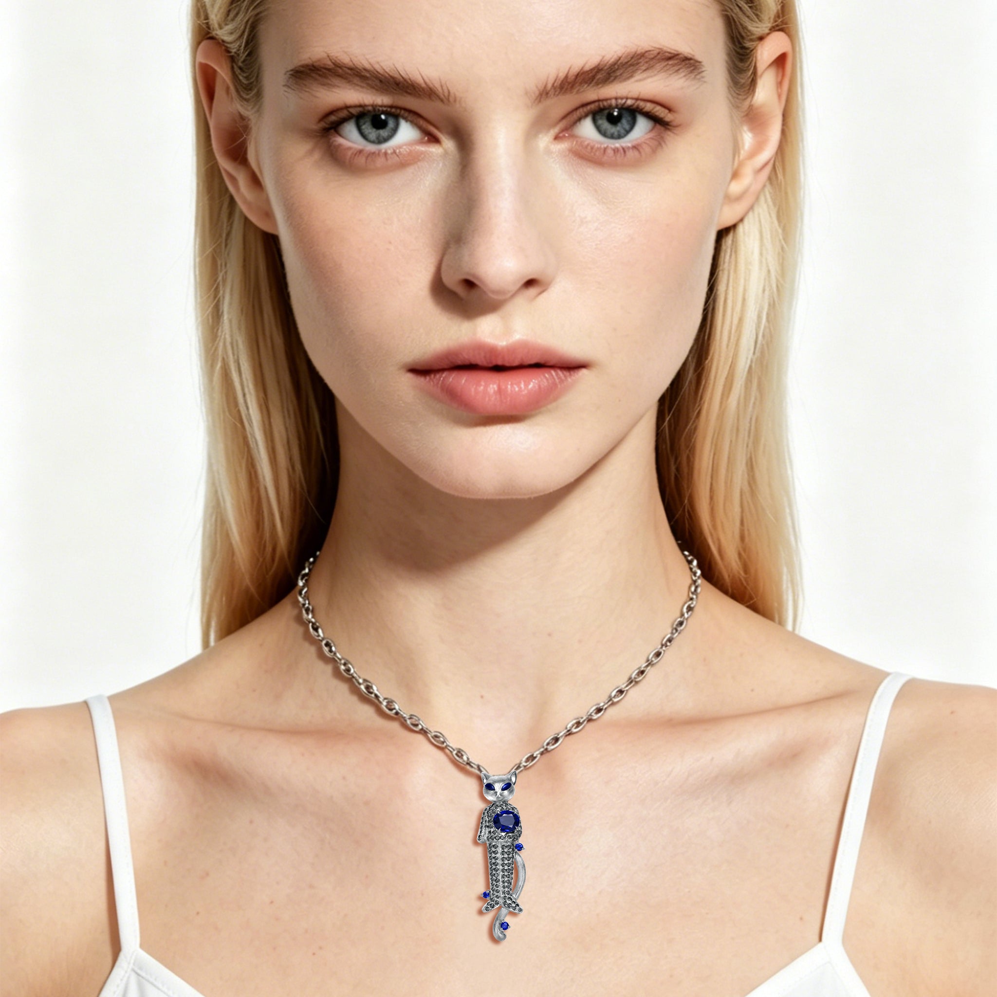 Model wearing TASA 18K white gold blue sapphire and black diamond cat pendant necklace, lifestyle portrait on white background