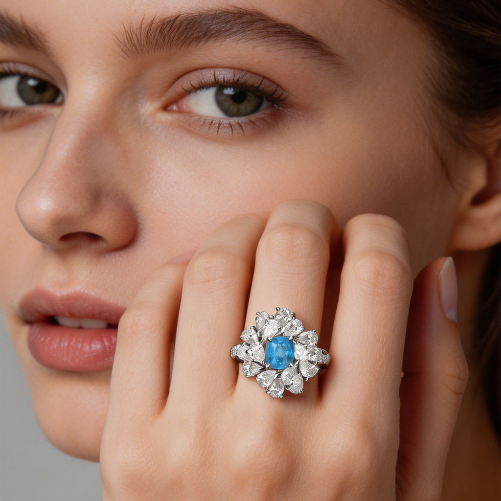 Model wearing TASA certified Brazilian Paraiba tourmaline diamond starburst cocktail ring, neon blue gemstone fine jewellery close-up portrait