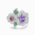 TASA 18K white gold double floral ring front view, Vivid Purple sapphire and ruby centre stones with tsavorite leaf accents and 203 pavé-set diamonds, white background